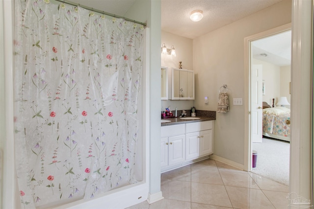 3017 Southsky Ln, Pensacola, FL 32506 - bathroom featuring vanity, tile patterned floors, a shower with curtain, baseboards, and a textured ceiling