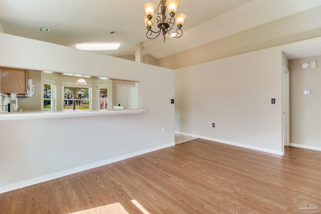 3881 Windsor Castle Blvd, Milton, FL 32583 - unfurnished living room with light wood-type flooring, a chandelier, baseboards, and vaulted ceiling