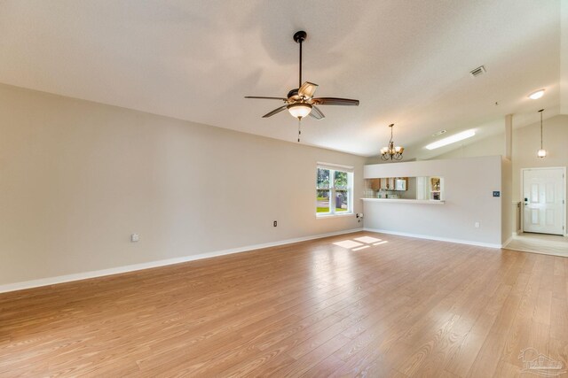 3881 Windsor Castle Blvd, Milton, FL 32583 - unfurnished living room with ceiling fan, lofted ceiling, a chandelier, light wood-style floors, and baseboards