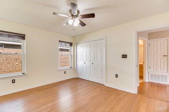 3881 Windsor Castle Blvd, Milton, FL 32583 - unfurnished bedroom featuring light wood-style floors, a closet, baseboards, ceiling fan, and a textured ceiling
