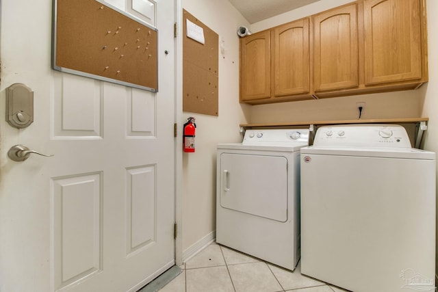 3881 Windsor Castle Blvd, Milton, FL 32583 - clothes washing area with washing machine and dryer, cabinet space, light tile patterned flooring, and baseboards