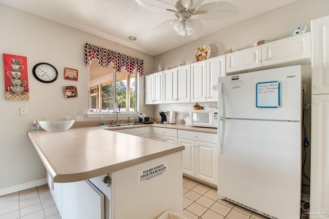 3881 Windsor Castle Blvd, Milton, FL 32583 - kitchen featuring white appliances, a peninsula, light tile patterned floors, a ceiling fan, and a textured ceiling
