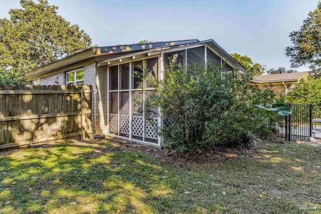 view of outbuilding featuring a sunroom and a yard