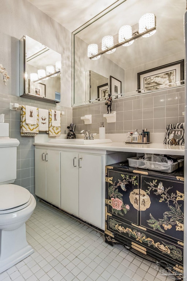 bathroom with tile patterned floors, vanity, tile walls, and toilet