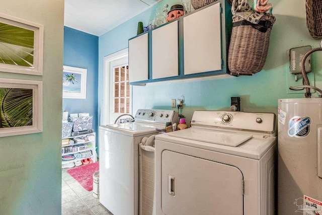 laundry area featuring cabinets, light tile patterned flooring, gas water heater, and independent washer and dryer