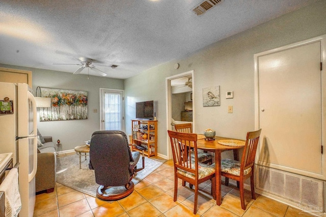 tiled dining room featuring ceiling fan and a textured ceiling