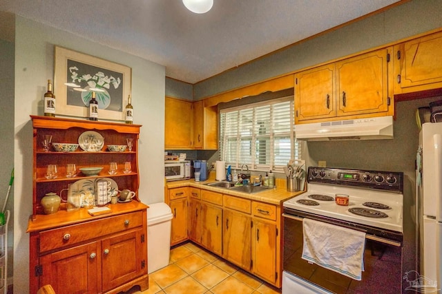 kitchen featuring sink, light tile patterned floors, and white appliances