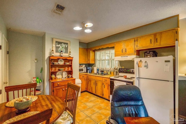 kitchen featuring light tile patterned flooring, sink, white appliances, and a textured ceiling