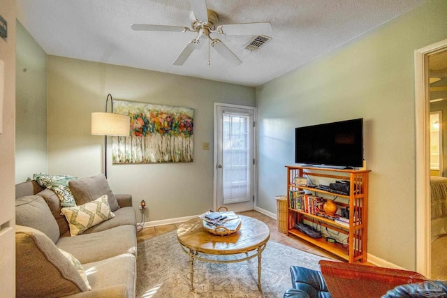 living room with a textured ceiling and ceiling fan