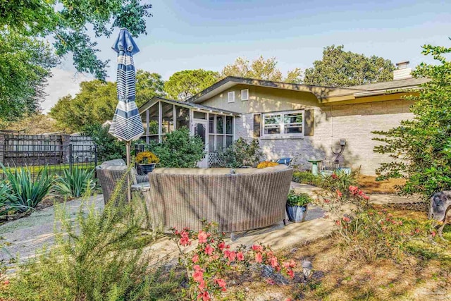 rear view of house with an outdoor living space and a sunroom