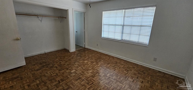 unfurnished bedroom with a closet and baseboards