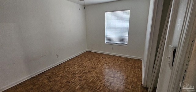 unfurnished room with baseboards