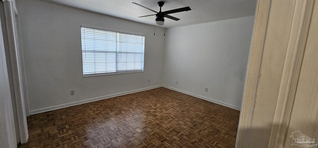 empty room featuring a ceiling fan and baseboards