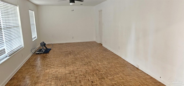 unfurnished room featuring ceiling fan and baseboards