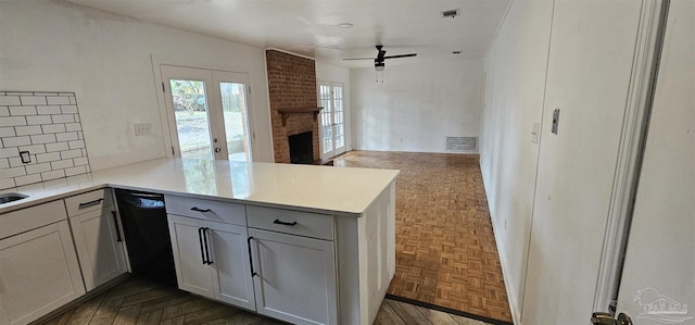 kitchen with tasteful backsplash, black dishwasher, visible vents, and a peninsula