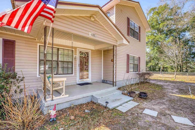 view of front of property featuring a porch and fence