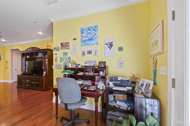 office space with visible vents, ornamental molding, a textured ceiling, wood finished floors, and baseboards