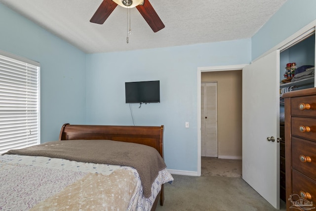 bedroom featuring a ceiling fan, light colored carpet, a textured ceiling, and baseboards