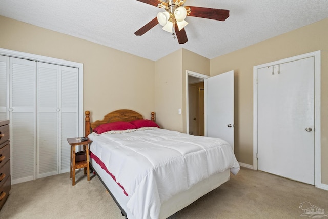 bedroom with light carpet, baseboards, a ceiling fan, and a textured ceiling