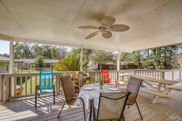 wooden terrace with outdoor dining space, a fenced backyard, and a ceiling fan