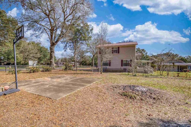 exterior space with basketball hoop and fence