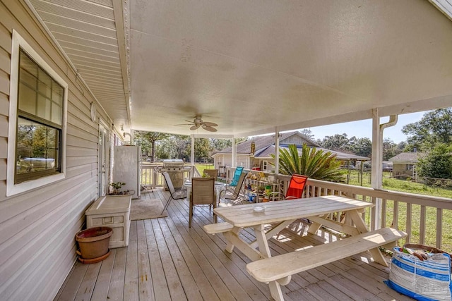 wooden terrace with ceiling fan and outdoor dining area