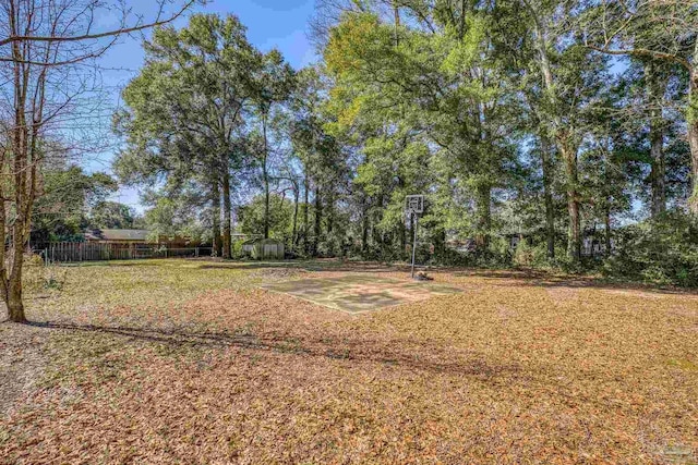 view of yard with a storage shed, fence, and an outbuilding