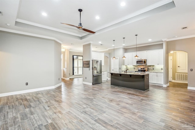 kitchen with white cabinetry, light hardwood / wood-style flooring, an island with sink, and stainless steel appliances