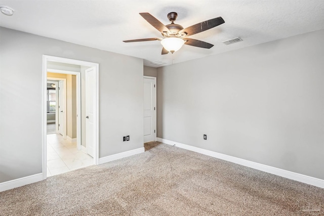 unfurnished bedroom featuring a textured ceiling, light colored carpet, and ceiling fan