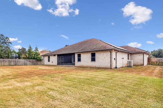 rear view of house featuring a lawn and cooling unit