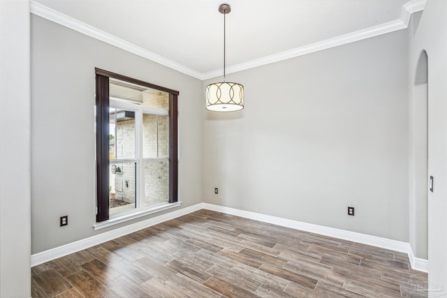 empty room featuring hardwood / wood-style floors and crown molding