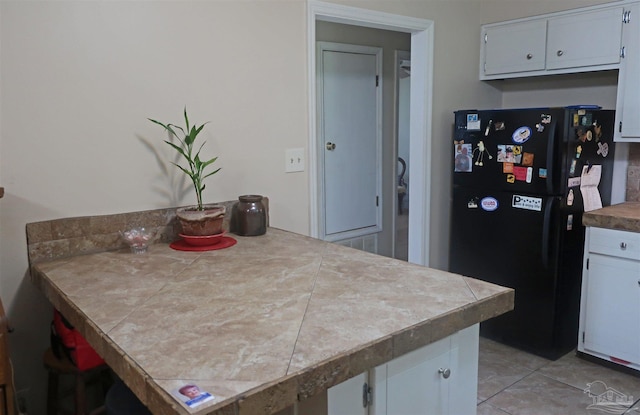 6150 Forest Pines Dr, Pensacola, FL 32526 - kitchen featuring freestanding refrigerator, white cabinetry, and light tile patterned floors