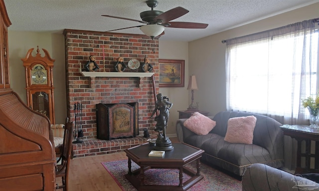 6150 Forest Pines Dr, Pensacola, FL 32526 - living room with ceiling fan, a textured ceiling, wood finished floors, and a brick fireplace