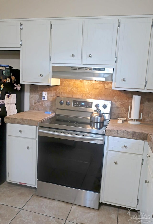 6150 Forest Pines Dr, Pensacola, FL 32526 - kitchen with electric range, under cabinet range hood, white cabinetry, tasteful backsplash, and light tile patterned floors