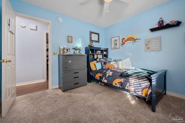 carpeted bedroom featuring a textured ceiling and ceiling fan