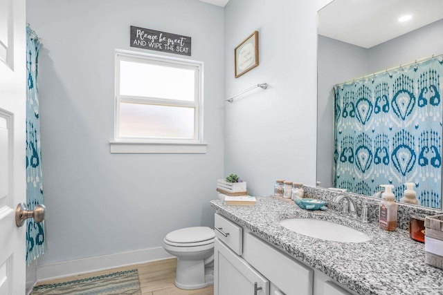 bathroom featuring vanity, hardwood / wood-style floors, and toilet