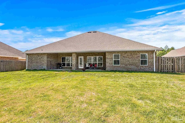 back of property with a patio and a yard