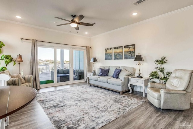 living room featuring ornamental molding, hardwood / wood-style floors, and ceiling fan