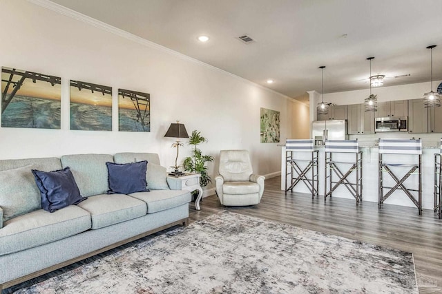 living room with dark wood-type flooring and crown molding