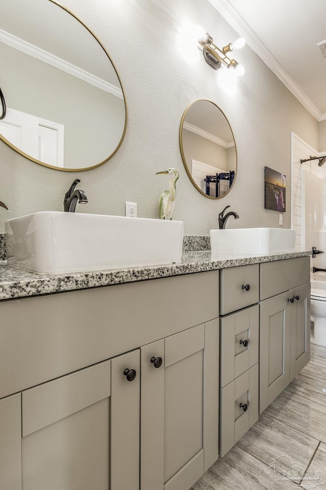 bathroom with a shower, wood-type flooring, toilet, vanity, and crown molding