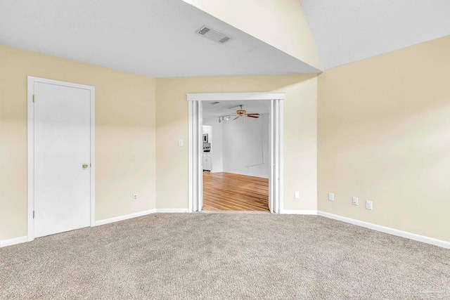 carpeted empty room featuring baseboards, visible vents, and a ceiling fan
