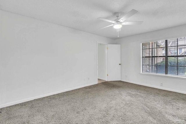 unfurnished room with baseboards, ceiling fan, carpet floors, and a textured ceiling