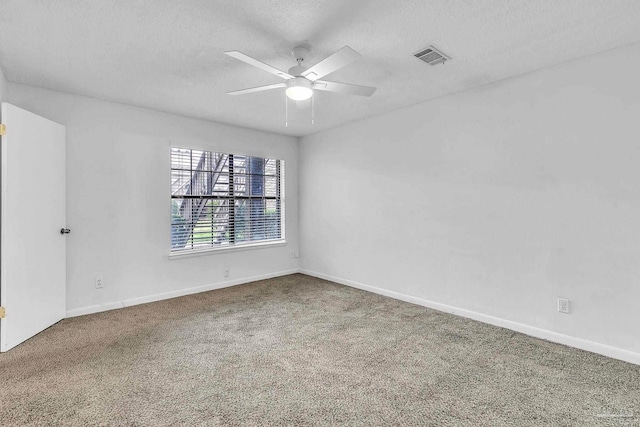 unfurnished room with carpet floors, a textured ceiling, baseboards, and visible vents