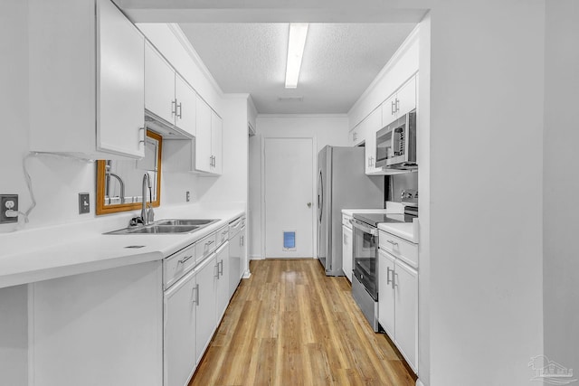 kitchen featuring light countertops, a sink, appliances with stainless steel finishes, a textured ceiling, and white cabinets
