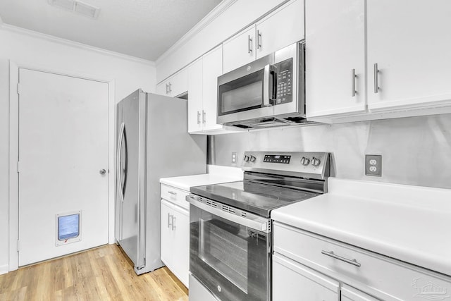 kitchen featuring ornamental molding, visible vents, stainless steel appliances, and light countertops