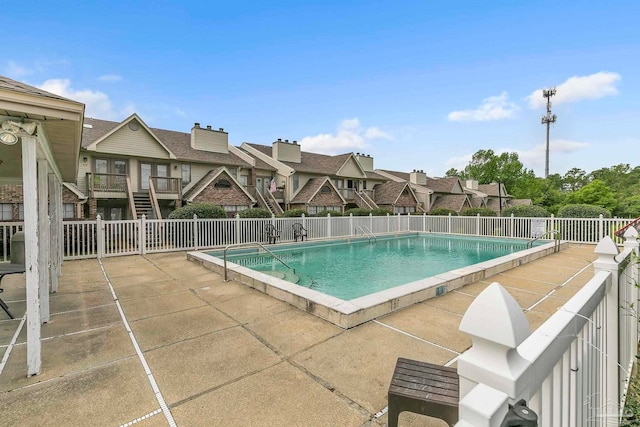 pool featuring fence, a deck, a patio, and stairway