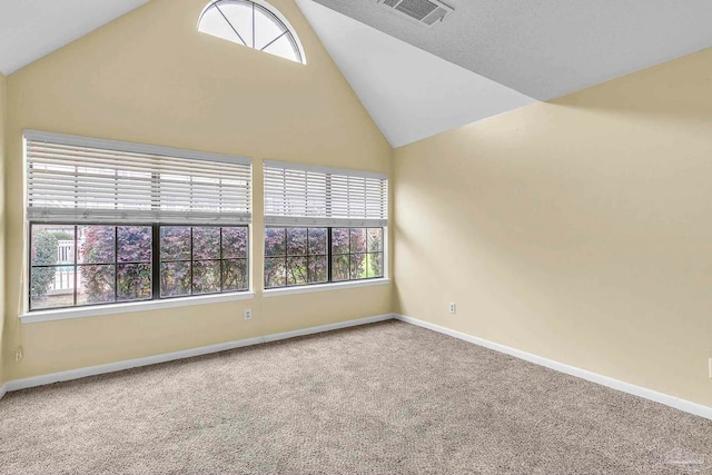 carpeted spare room featuring baseboards, visible vents, and high vaulted ceiling