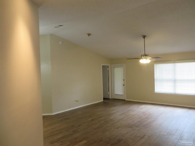 unfurnished room with vaulted ceiling, dark wood-style flooring, baseboards, and a ceiling fan