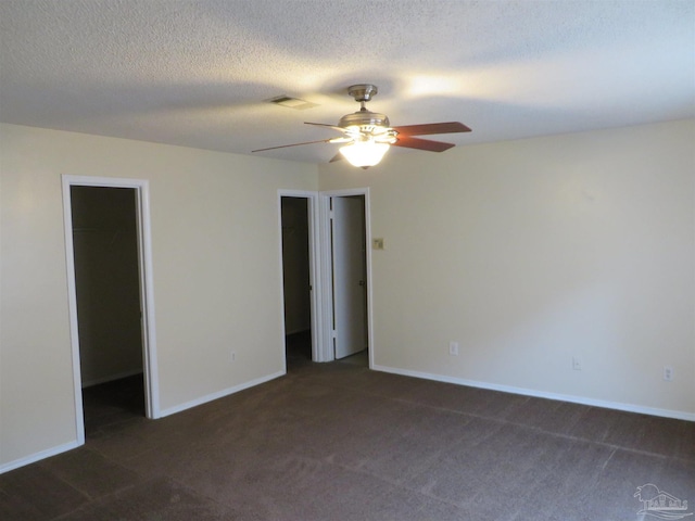 carpeted empty room with visible vents, baseboards, a ceiling fan, and a textured ceiling