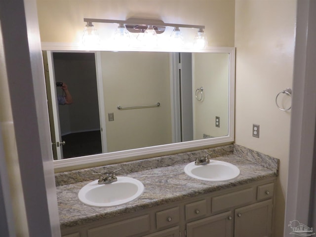 full bathroom with a sink and double vanity